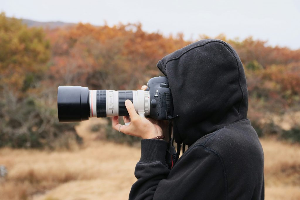 Fotografía de modelos en otoño. Fotógrafo con cámara en el campo